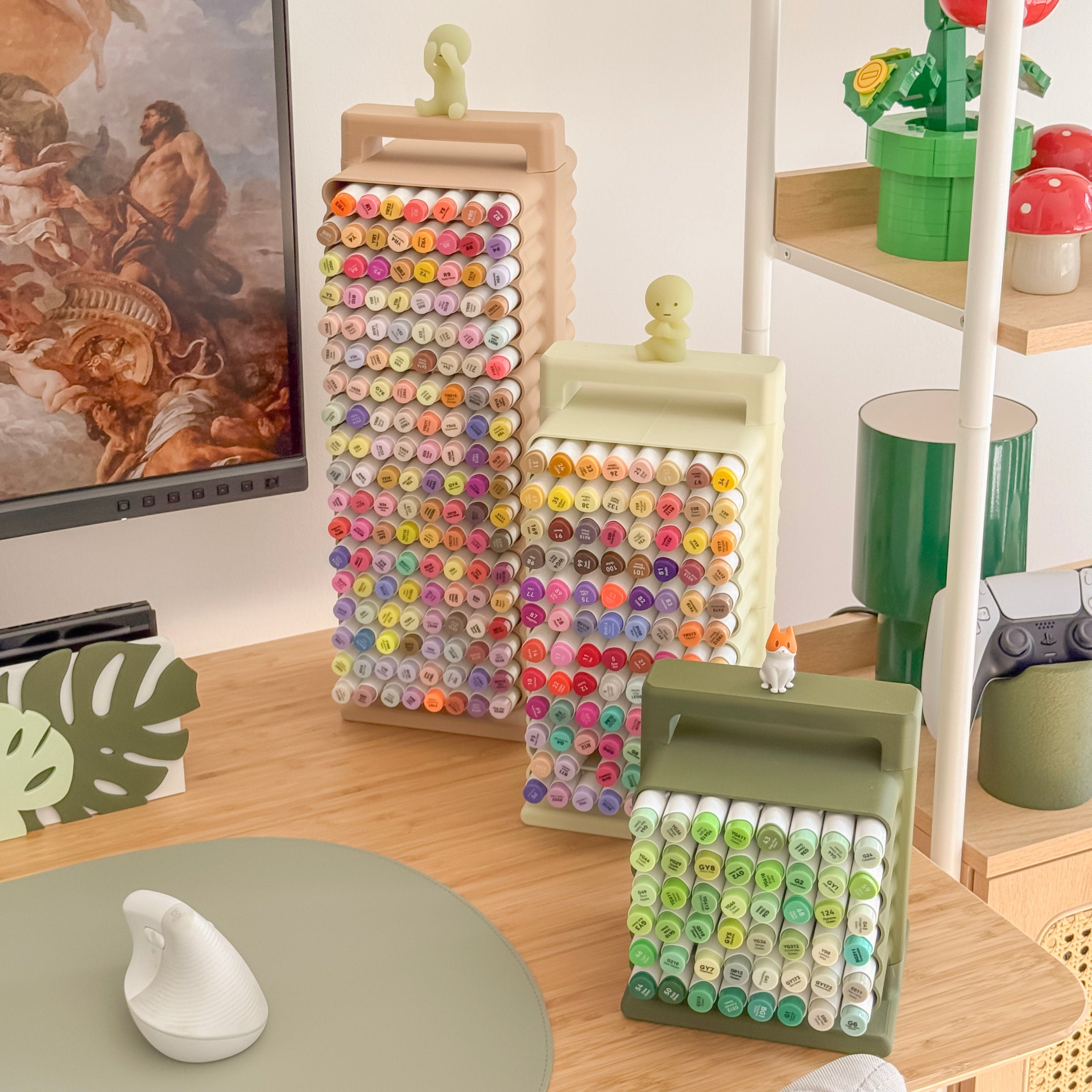 Colorful markers on a desk with a computer and decorative items.